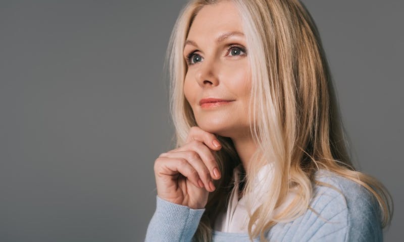 a woman with blonde hair and blue sweater looking up