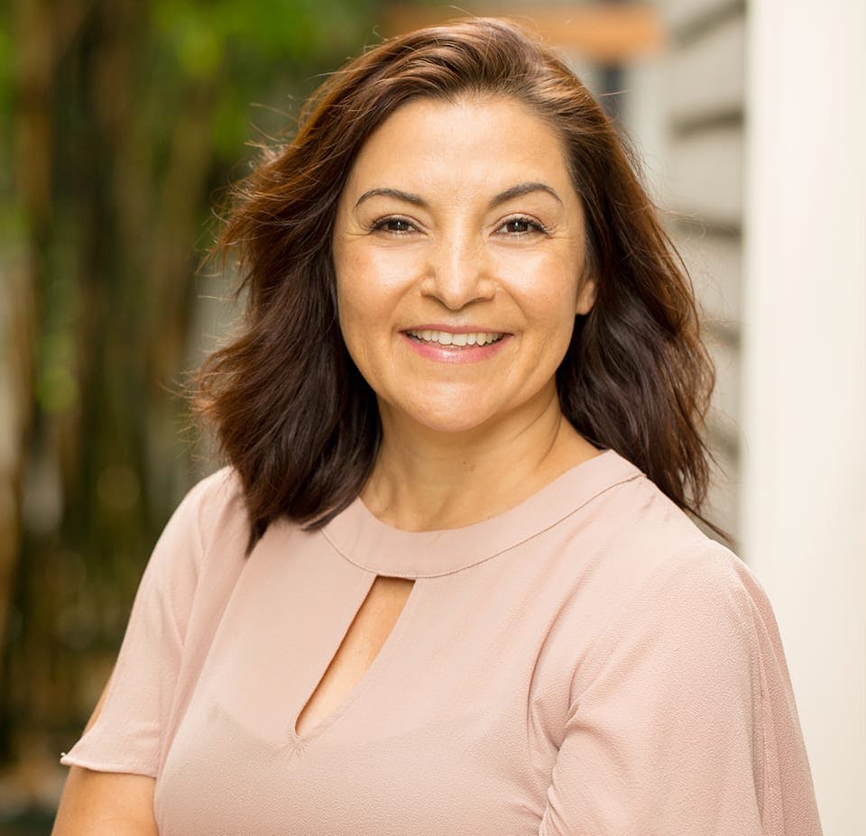 woman in a blush top smiling