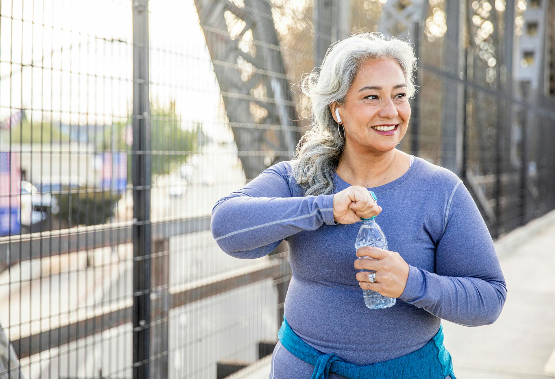 woman drinking water while on a walk