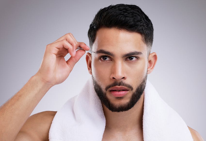 man pluking his eyebrows