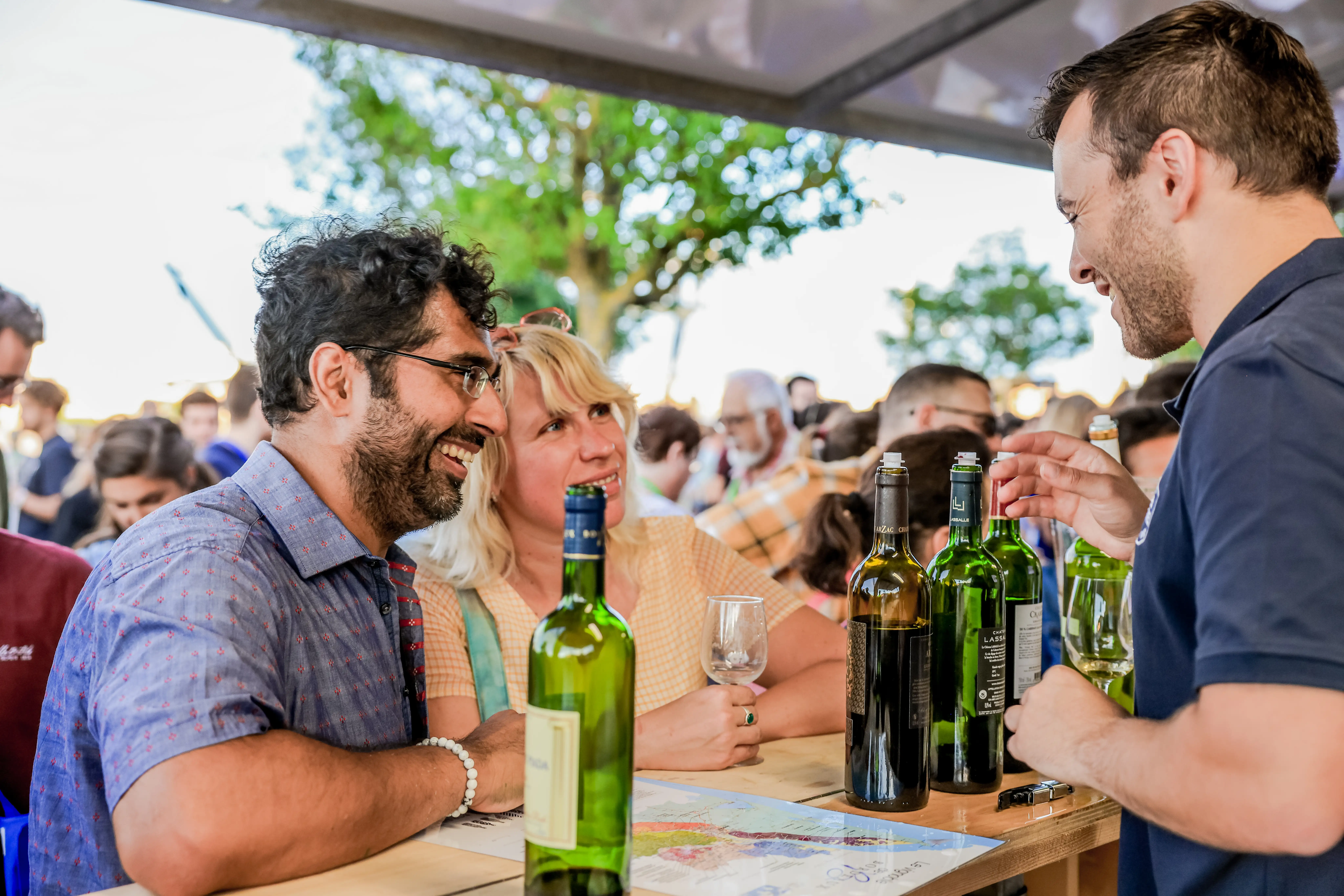 Des visiteurs échangent avec un vigneron autour des vins.