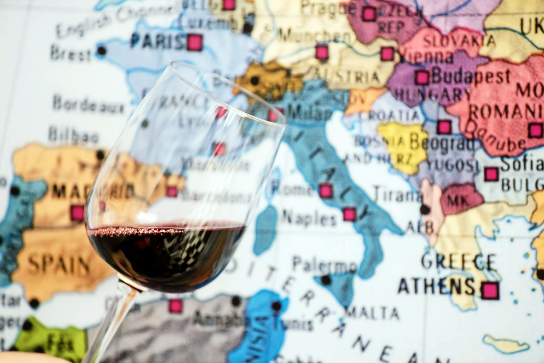 Glass of red wine in front of a world map