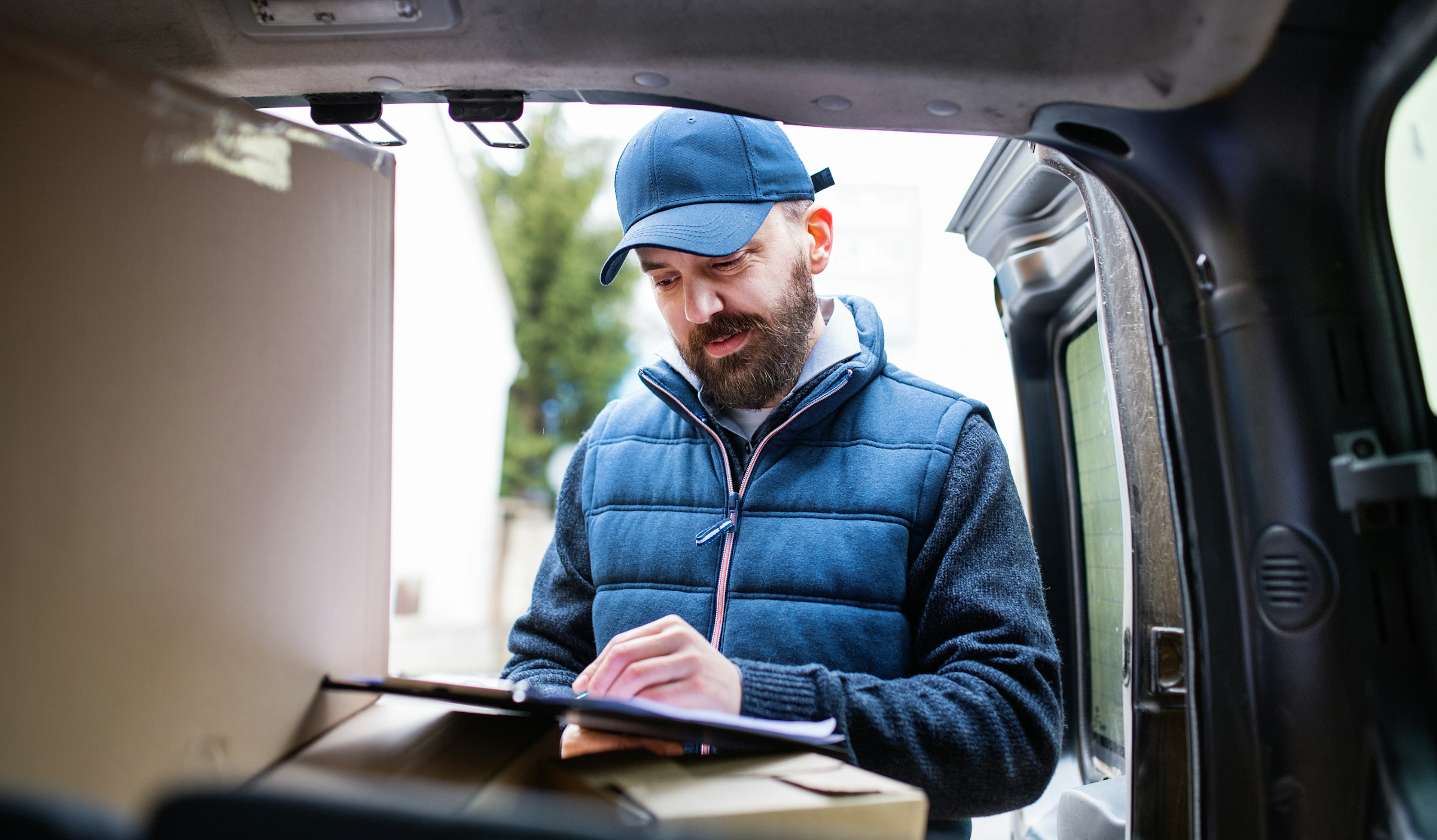 Last Mile Delivery driver inspecting route list on clipboard.