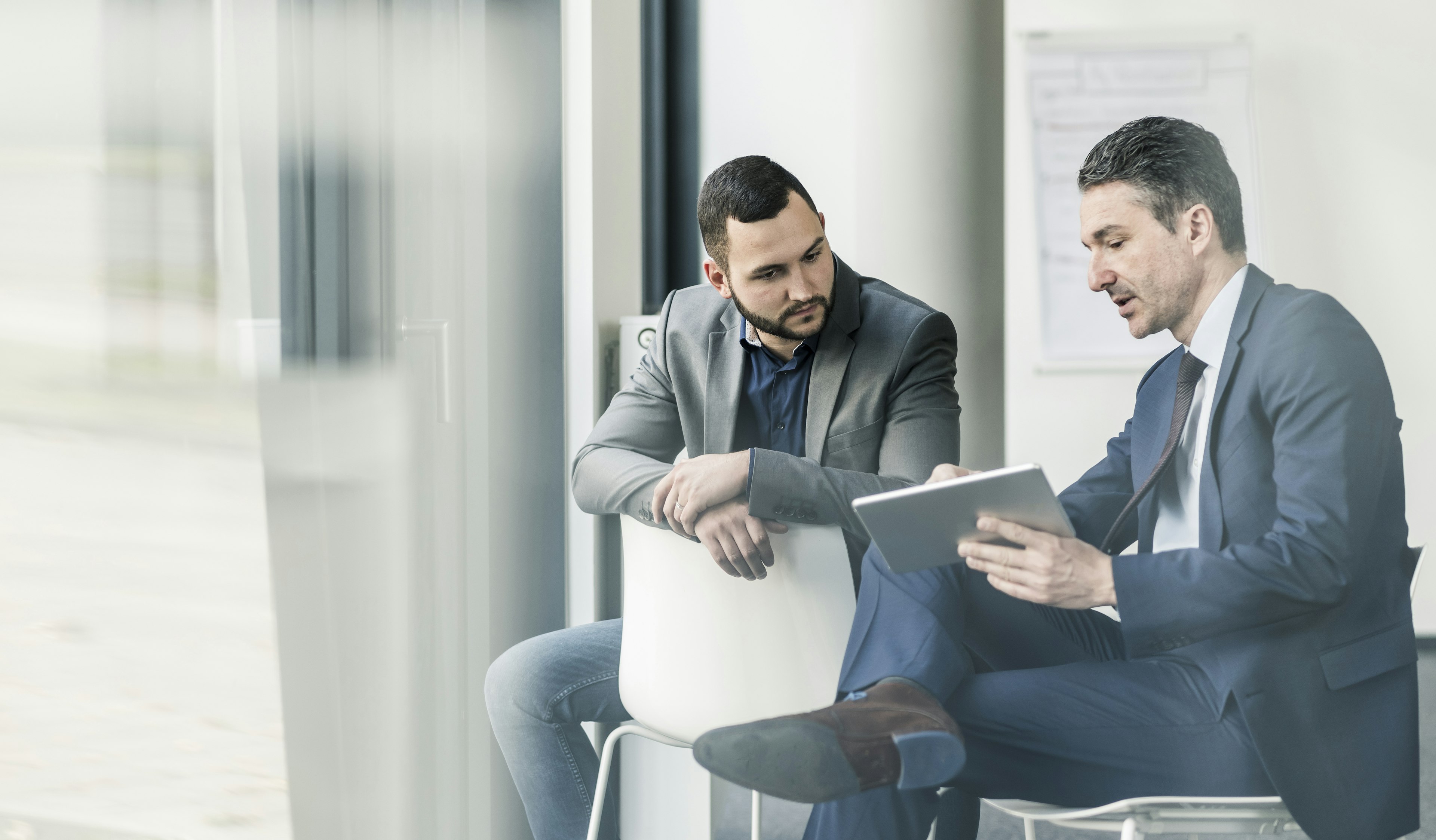 Two Men Looking at Tablet working on Mike Albert Partnership Management 