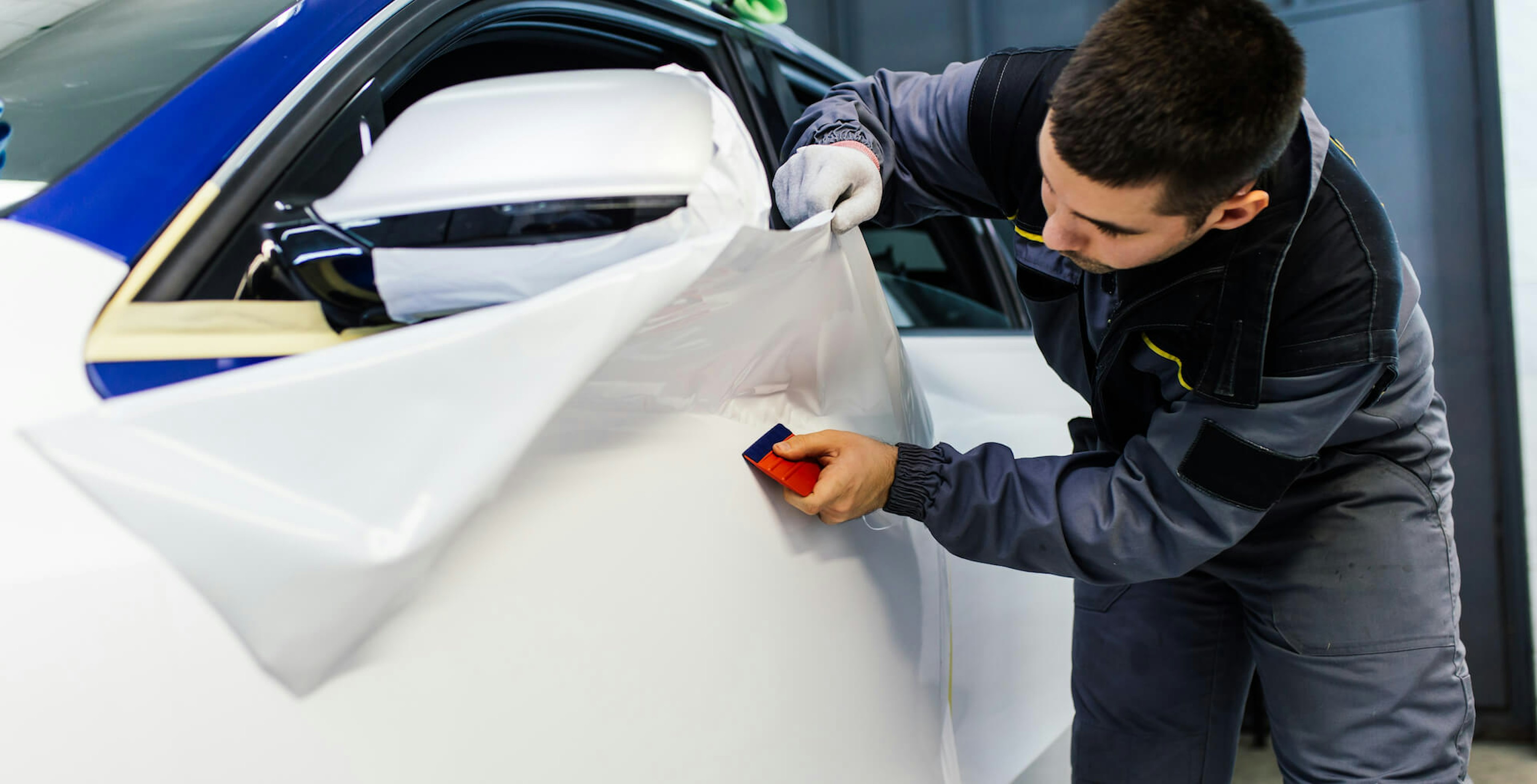 man putting car wrap on vehicle