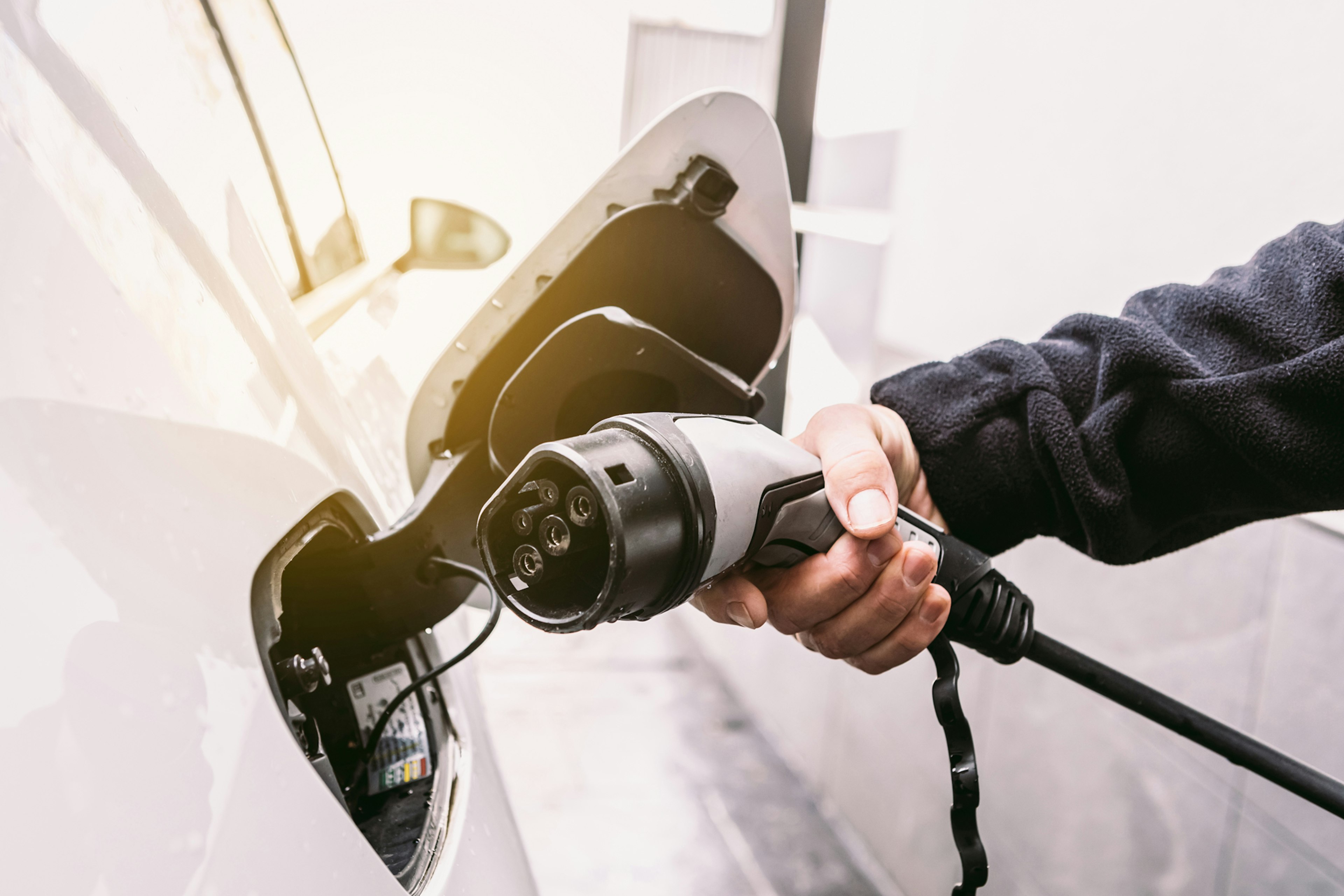 Person plugging in their electric fleet vehicle