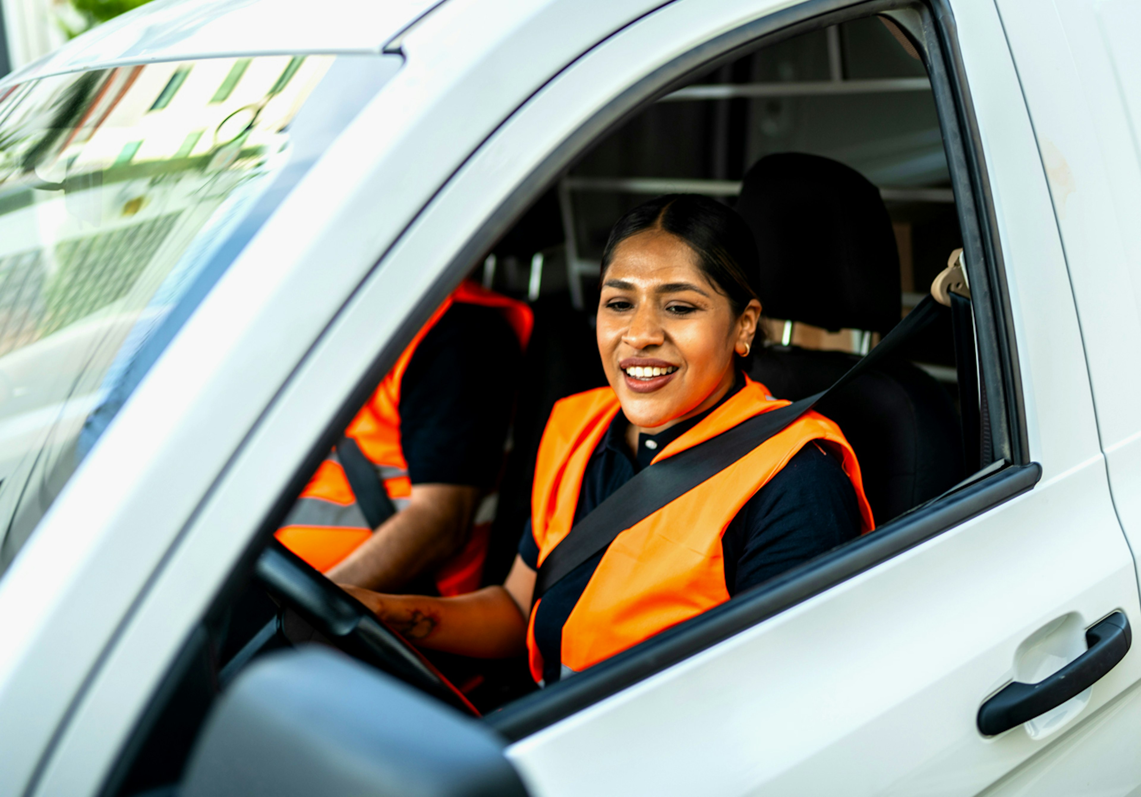 Female fleet driver with safety vest.