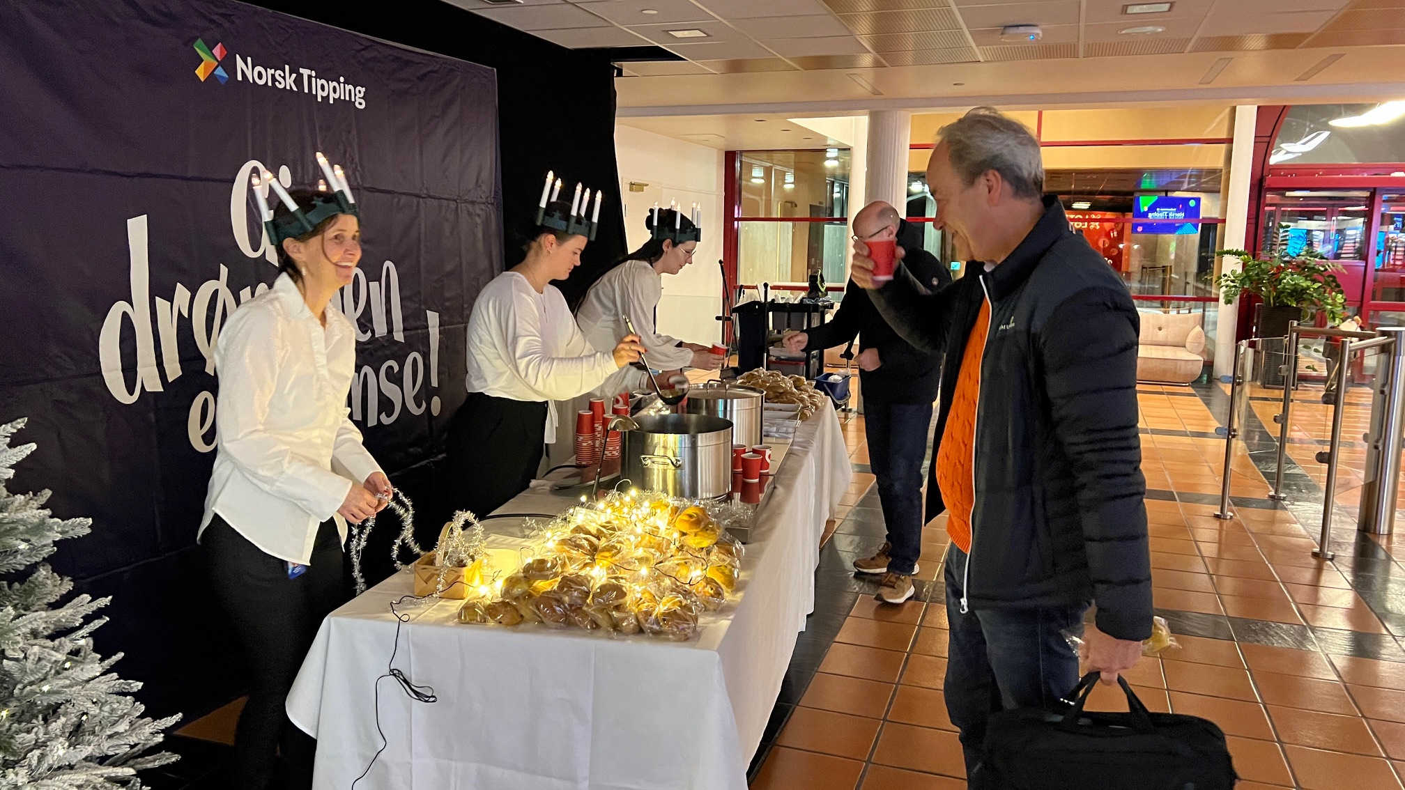 Norsk Tipping ansatte deler ut lussekatter og gløgg i resepsjonen.