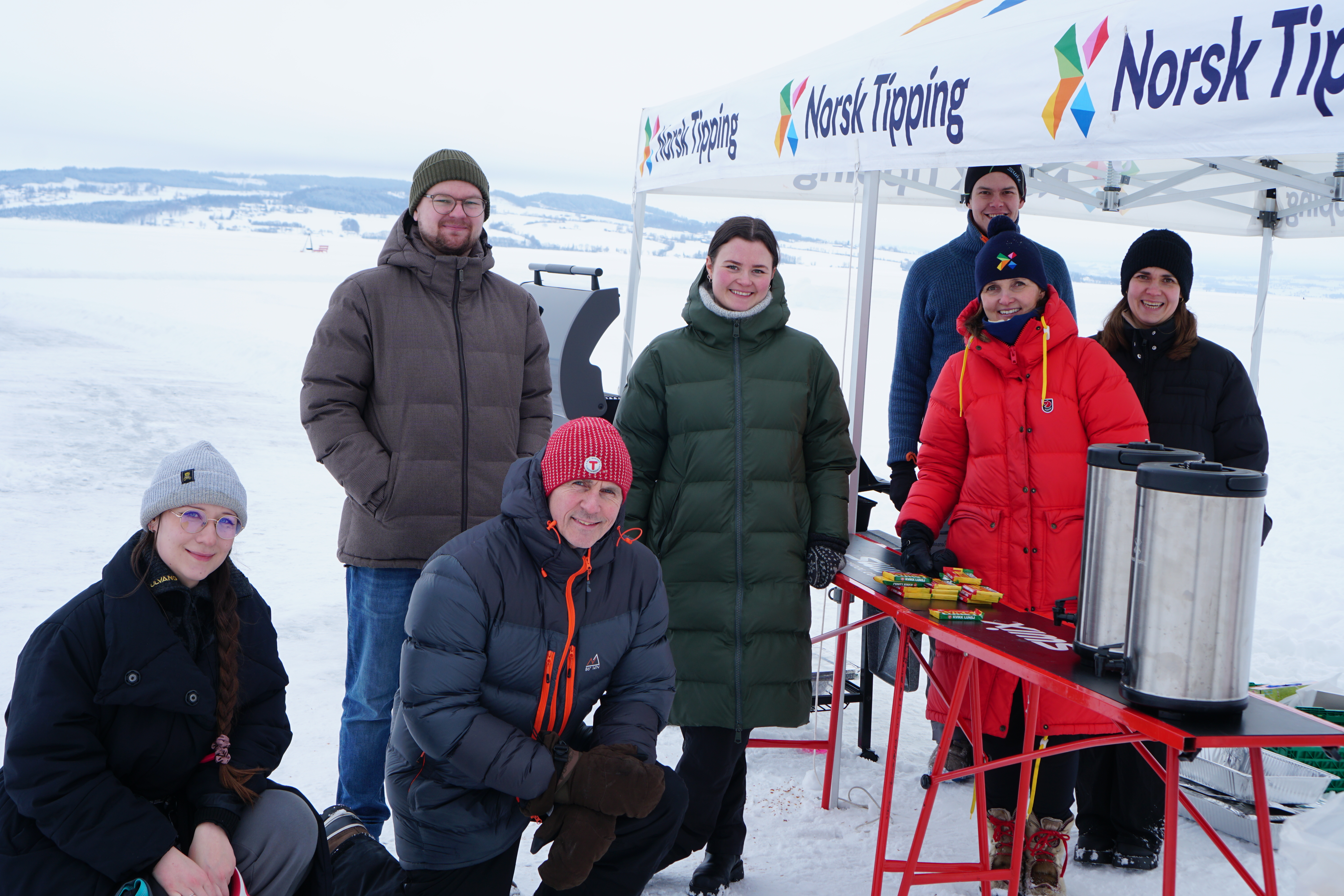 Gruppebilde av Norsk Tipping ansatte på skitur som får utdelt kaffe.