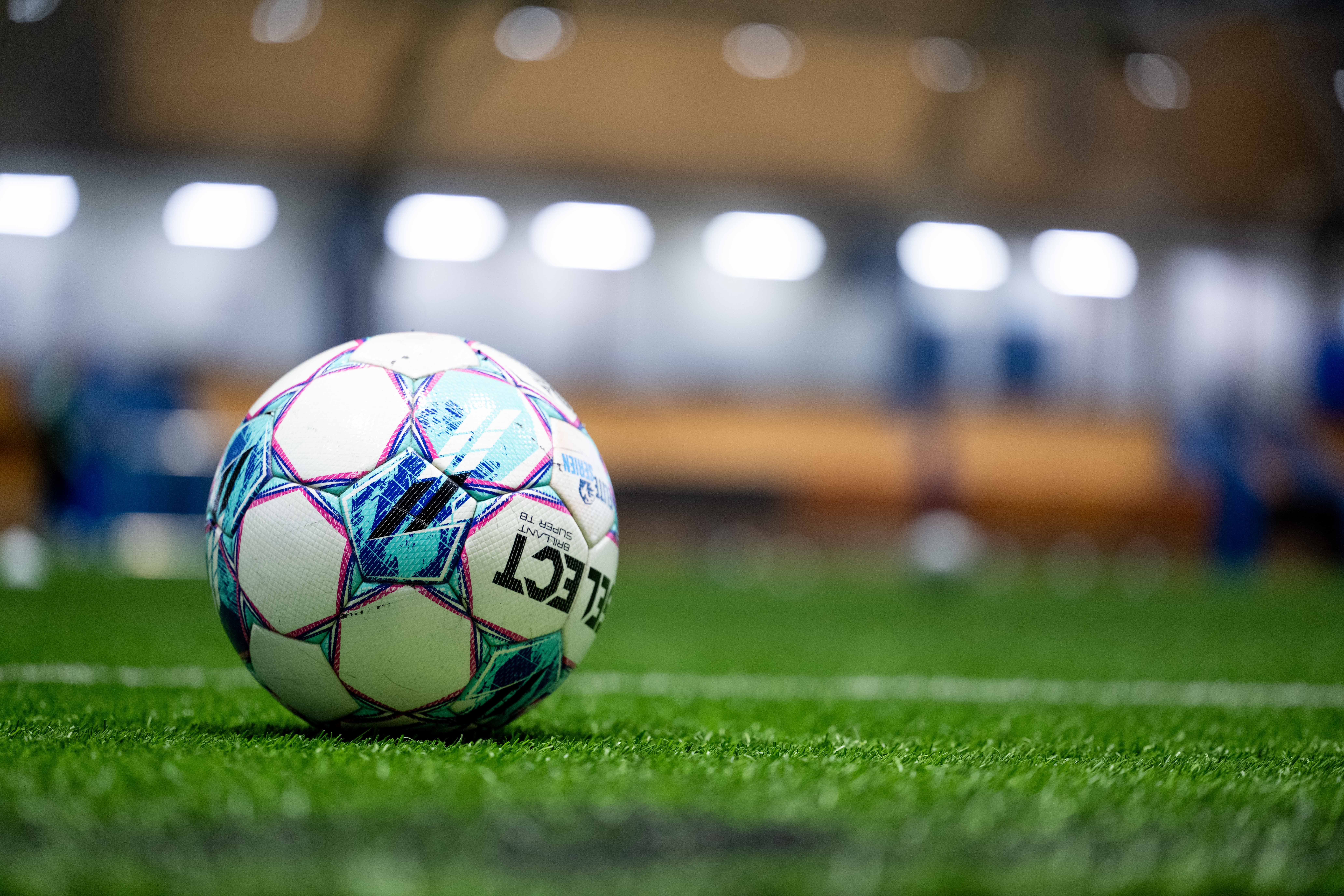 Fotball som ligger på kunstgress.