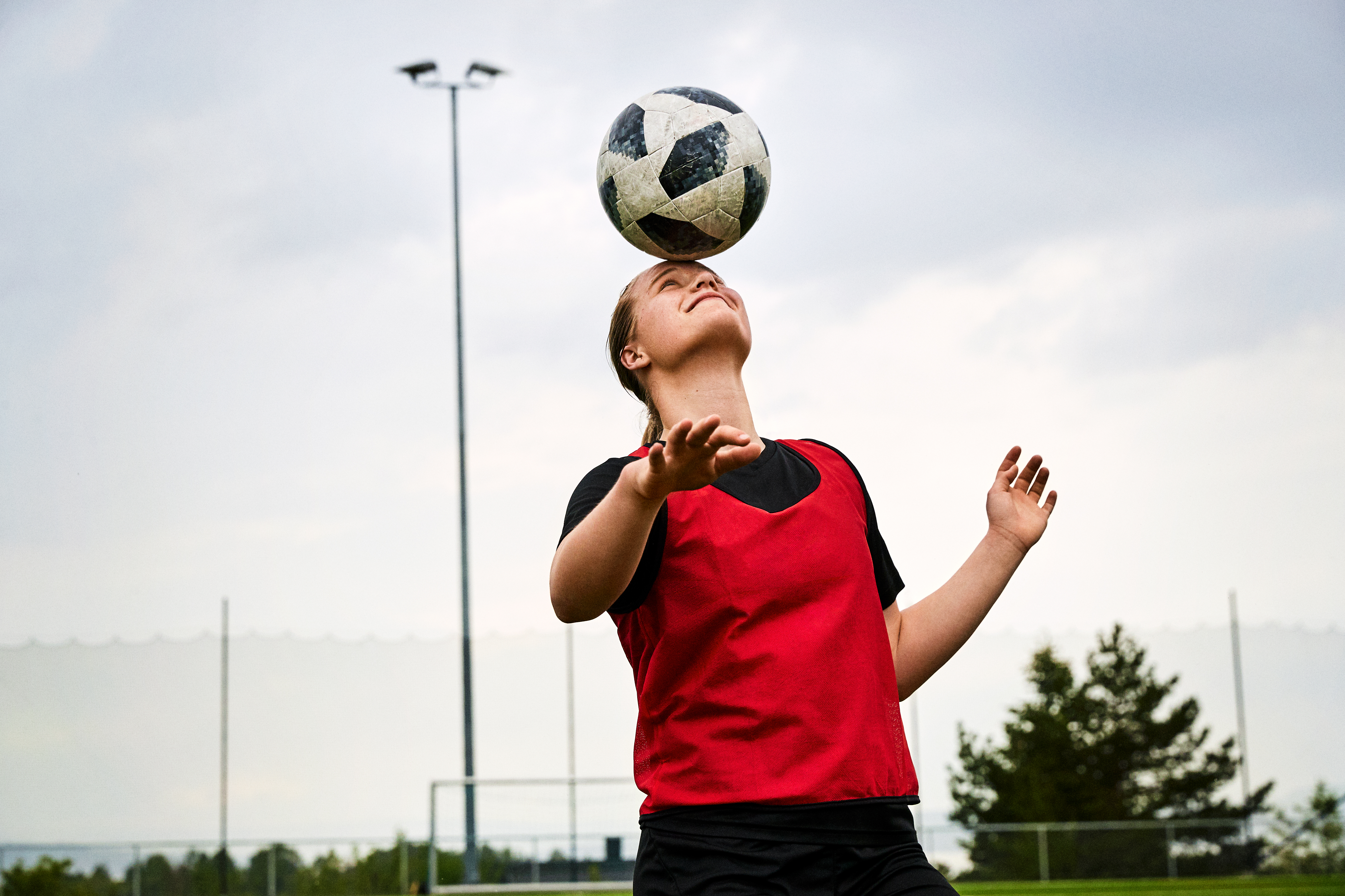 Kvinne som header en fotball.