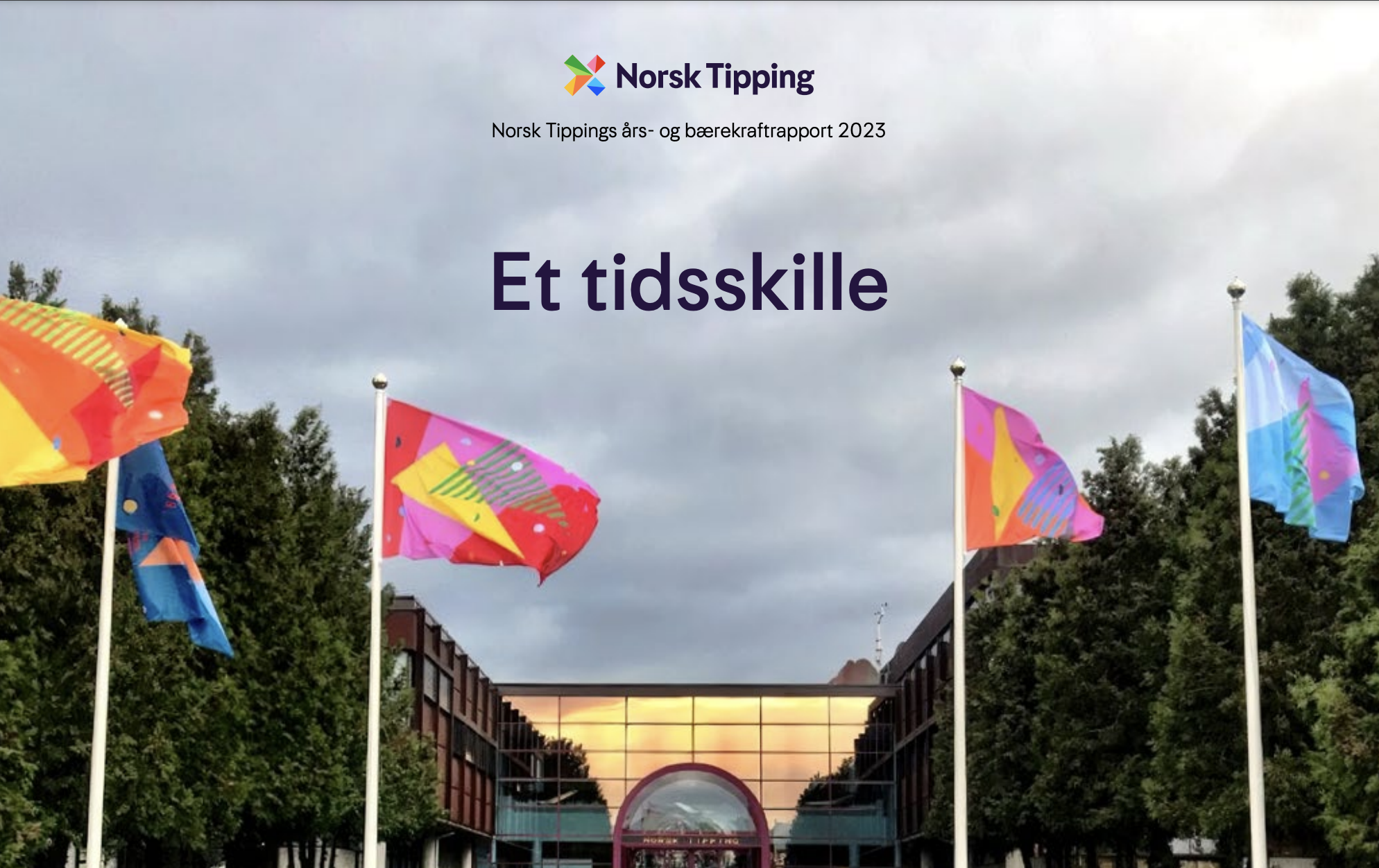 Foto av fasaden hos Norsk Tipping, inkl. flaggstenger med flagg på.