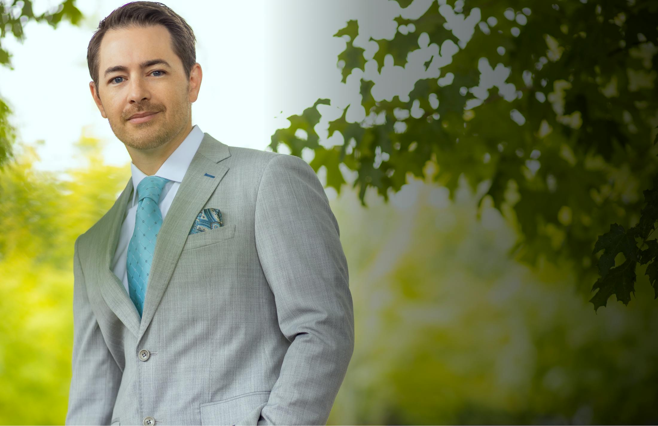 an image of Dr. Robb outside in a grey suit and blue tie