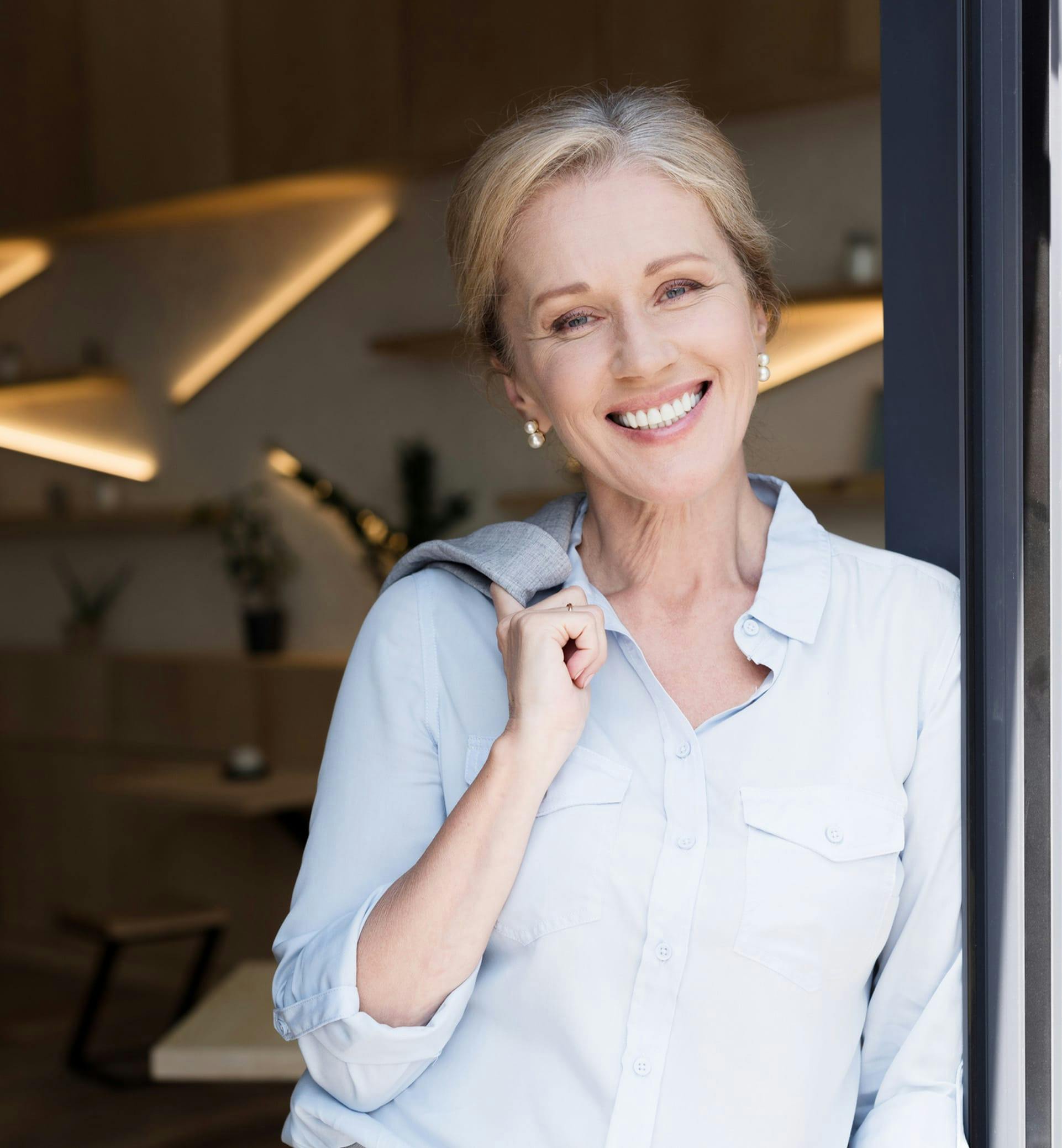 Middle aged woman posing in a doorway.