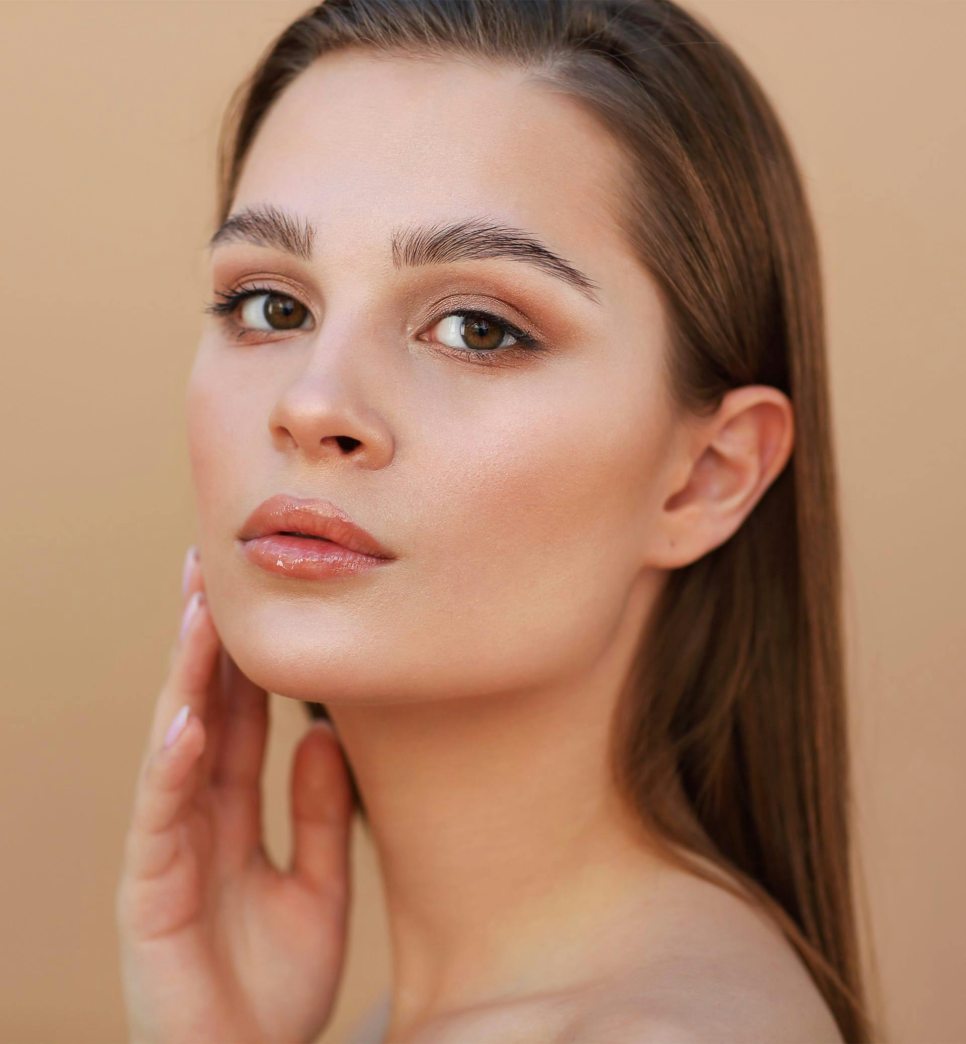 Woman posing while touching her face.
