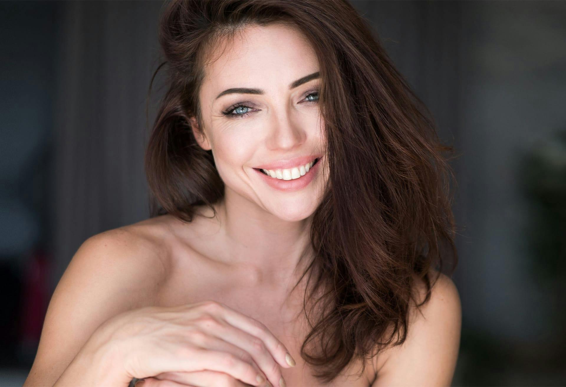 brunette woman with bright blue eyes smiling