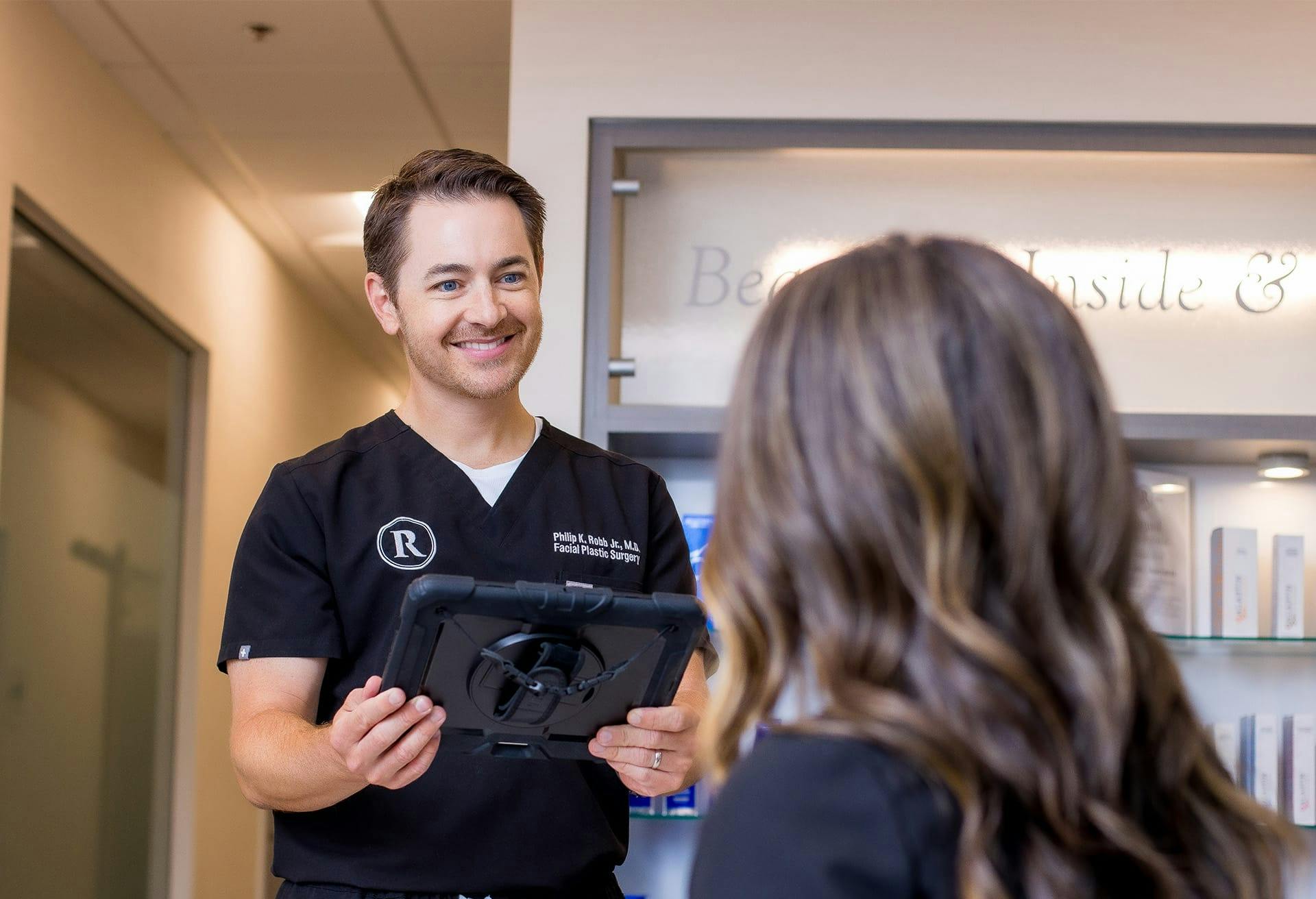 an image of Dr. Robb in the lobby with a patient, holding a black tablet