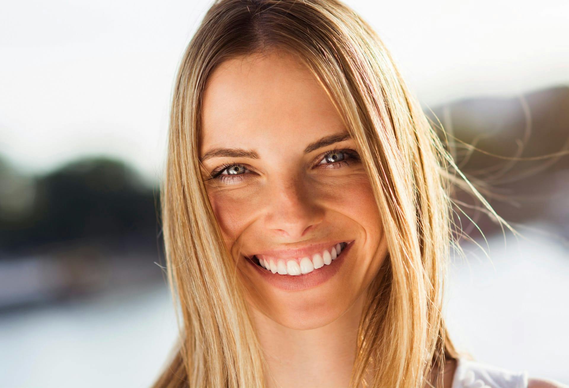 a close up of a blonde woman smiling