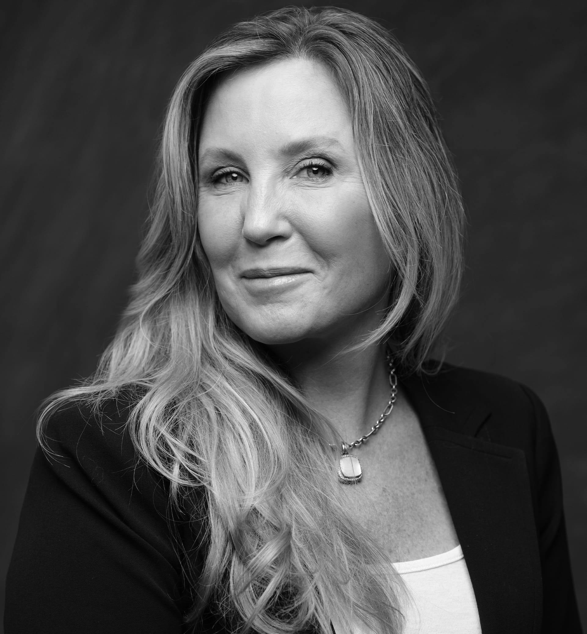 Black and white photo of a middle aged woman smiling.