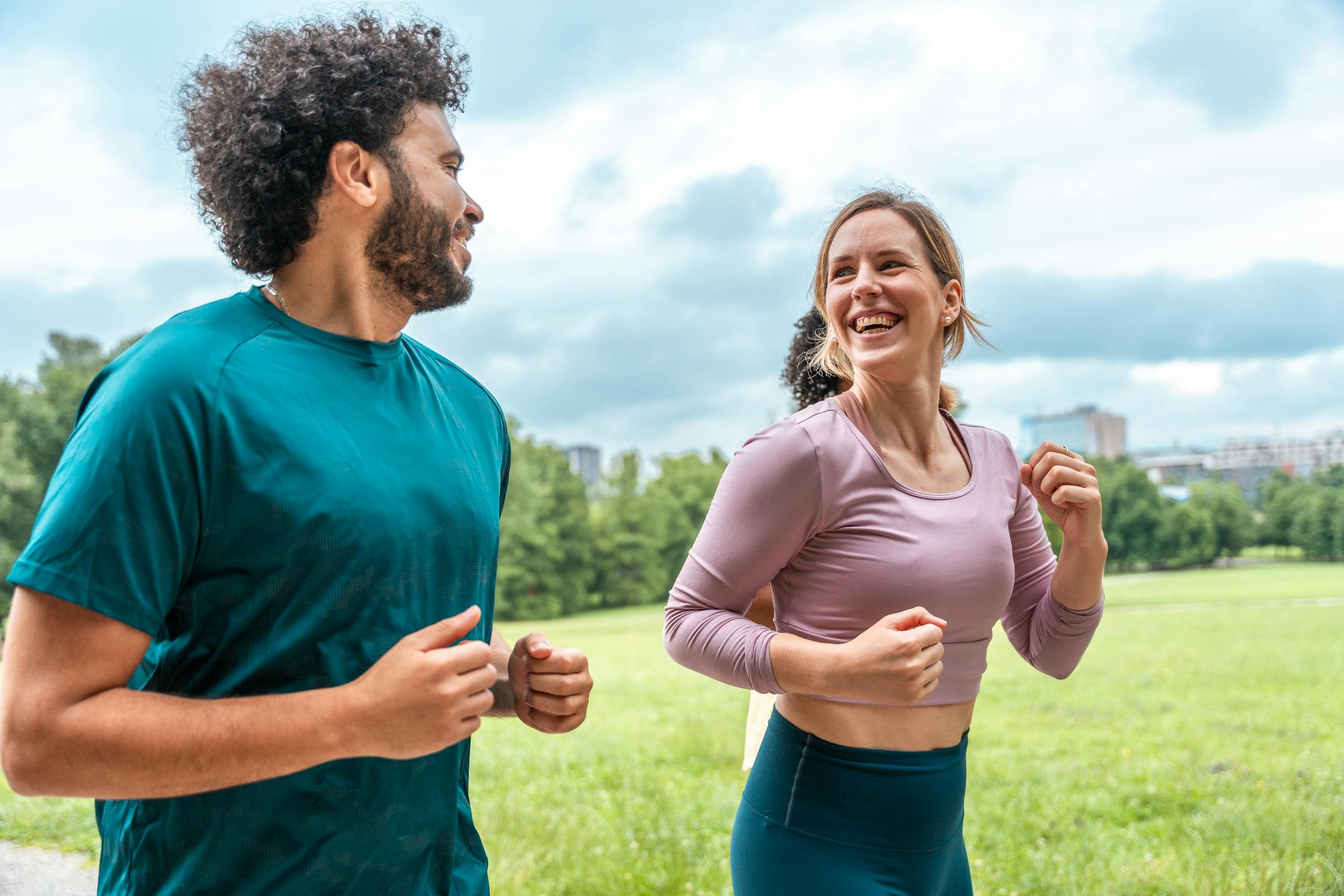 man and woman jogging in open field