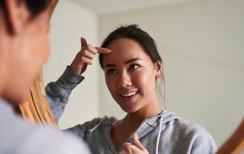 woman touching her forehead