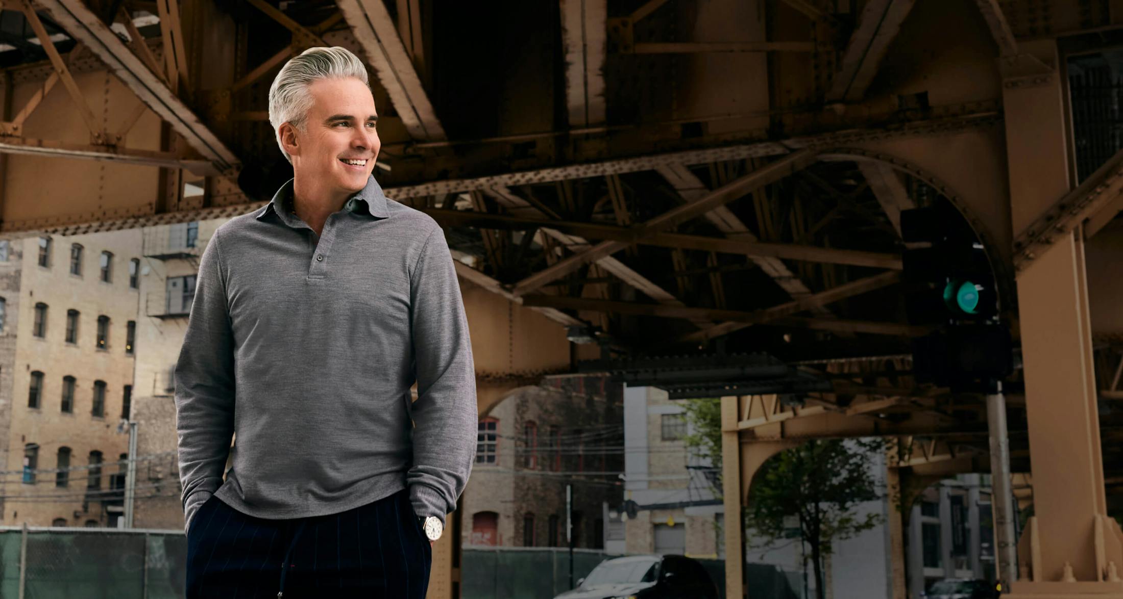 Dr. George Moynihan with hands in pockets smiling and looking at his left