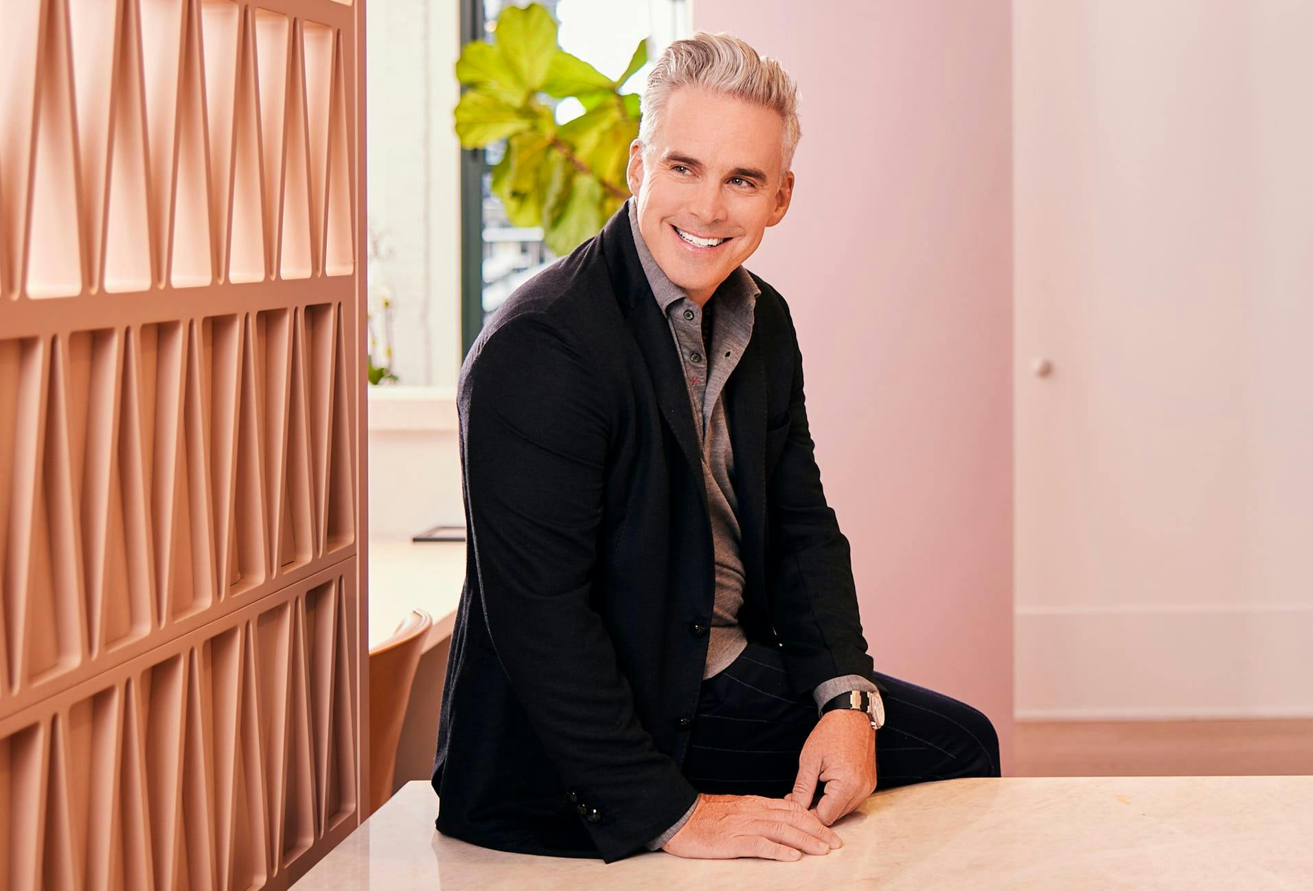 Dr. Moynihan smiling and sitting on table