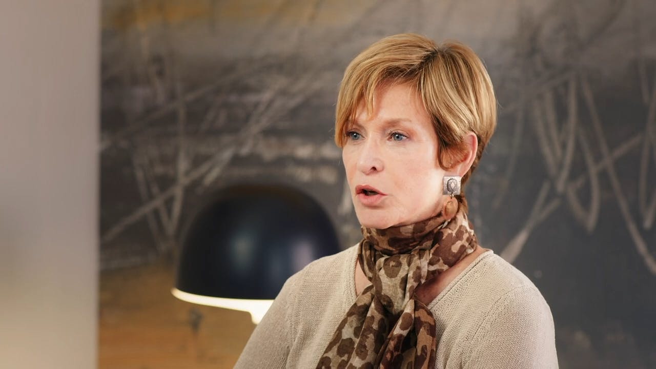 Woman wearing scarf sitting in front of lamp