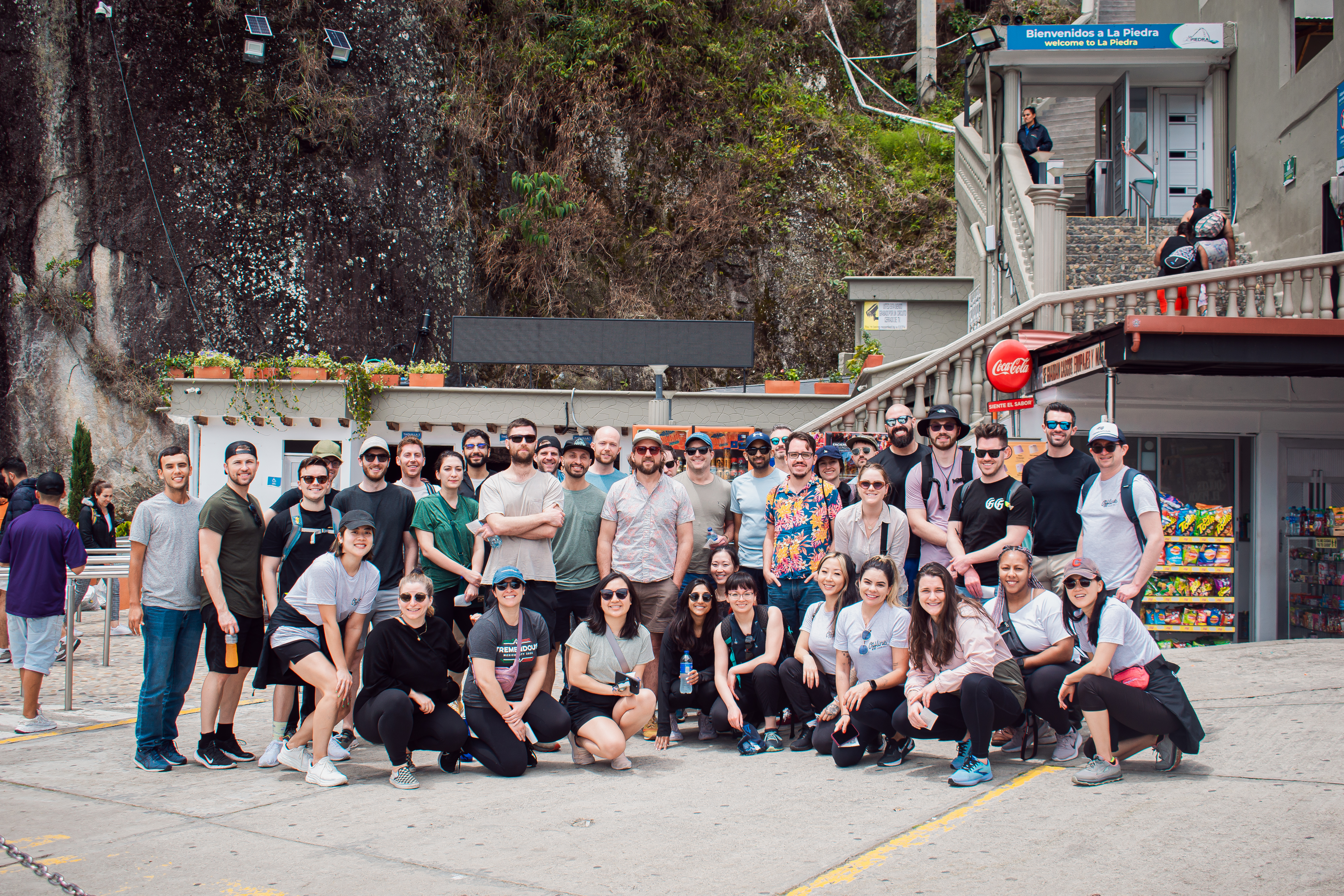 A group of coworkers standing at the base of a mountain.