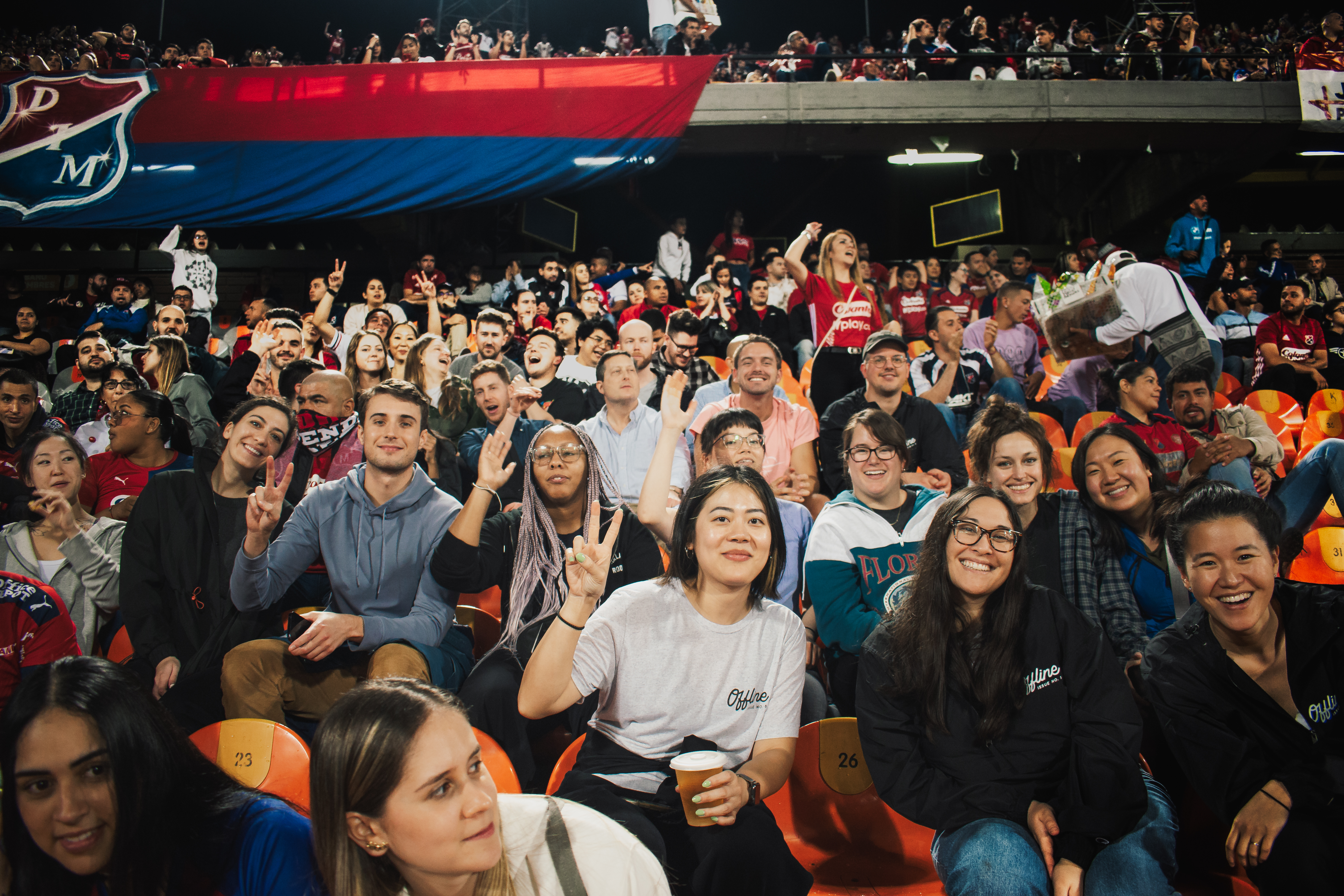 A group of coworkers sitting in the stands at a soccer game.