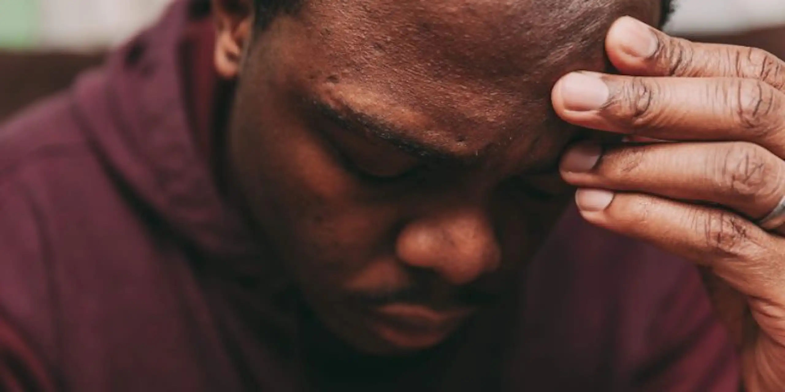 Man with hand on his head, look unwell due to his mental health