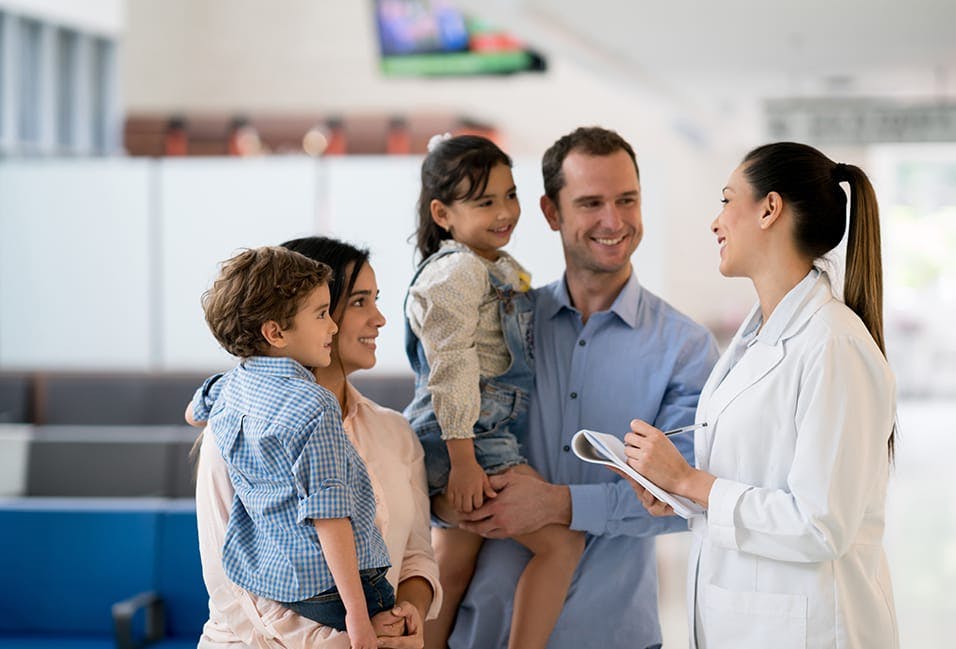 smiling family with two children and a doctor