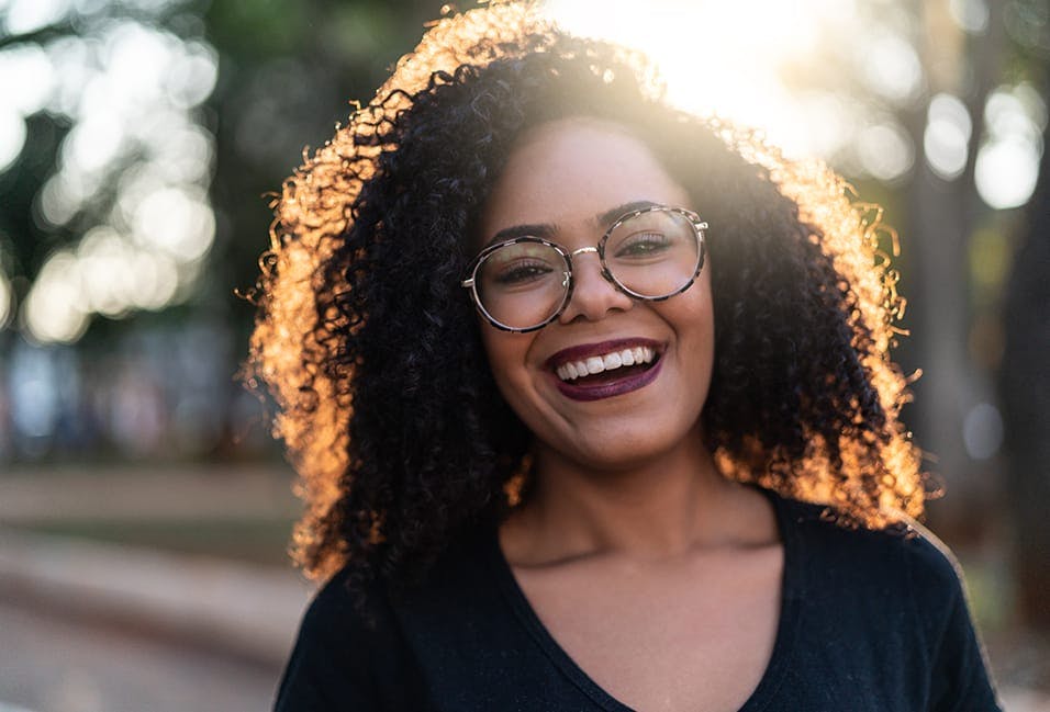 Woman wearing glasses smiling at the camera