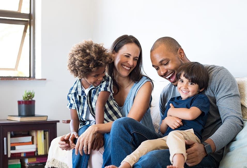 a man and woman sitting on a couch with two children