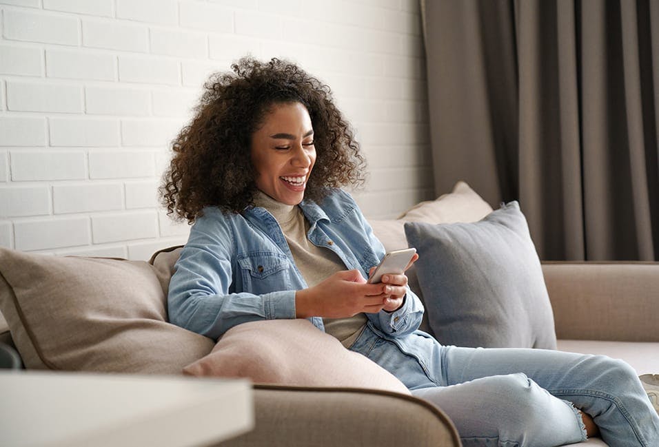 Smiling young woman looking at her phone