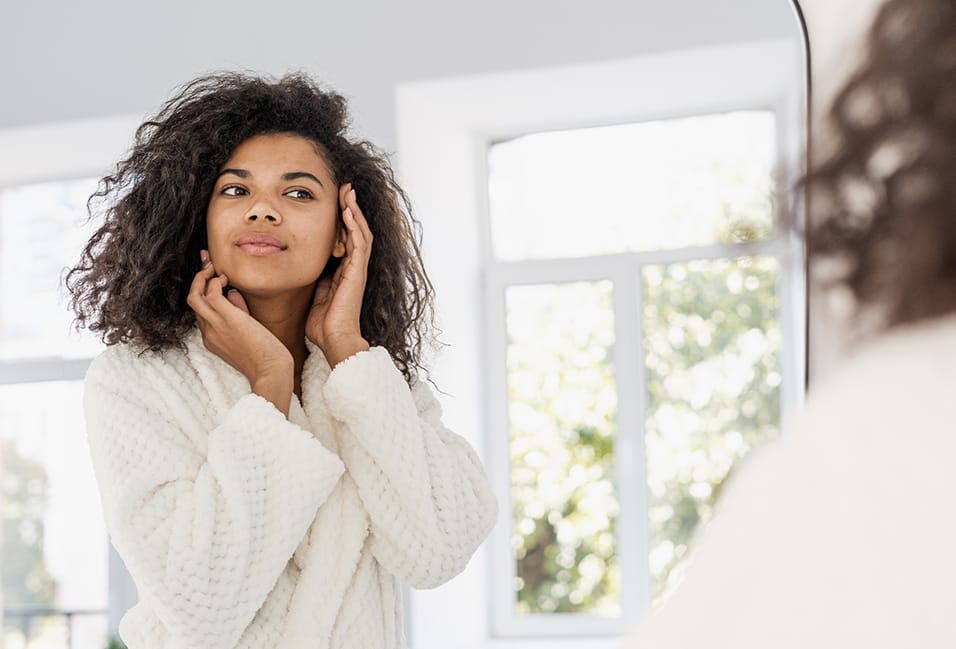 Young lady looking at herself in the mirror