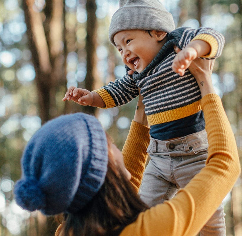 a woman holding a baby in the air