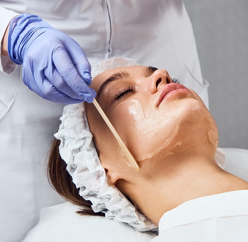woman getting a facial mask at a beauty salon