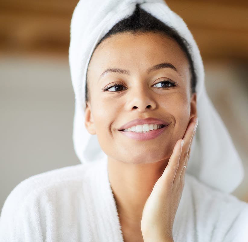 smiling woman in a towel wrapped around her head