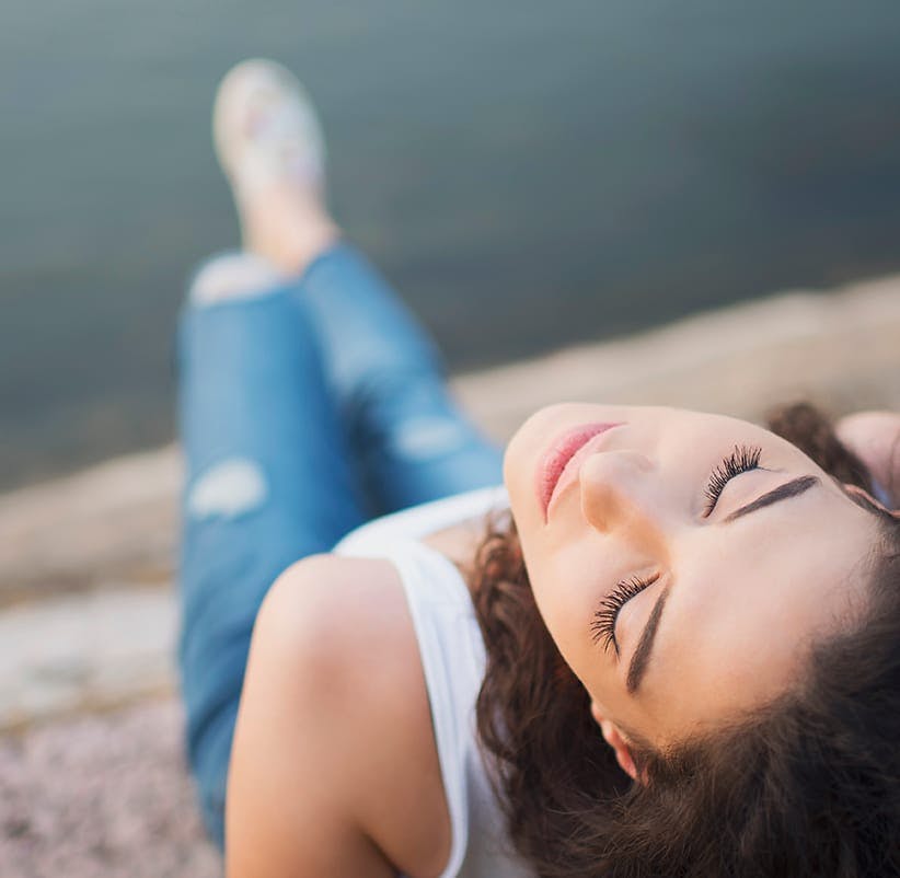 a woman laying on the ground with her eyes closed