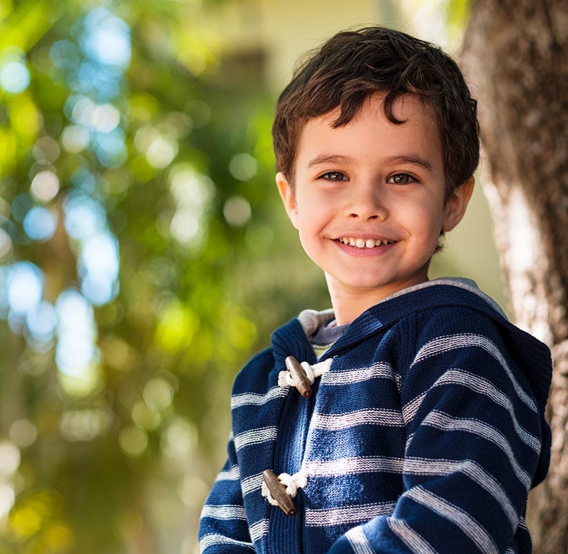 boy in a blue and white striped jacket smiling