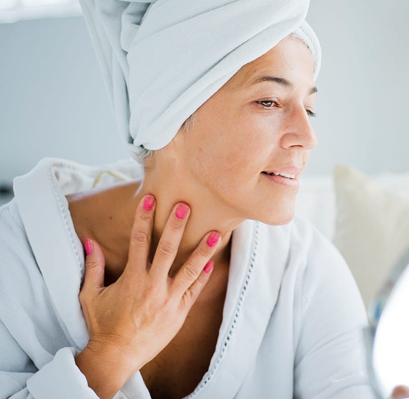 woman with pink nails and a white towel on her head