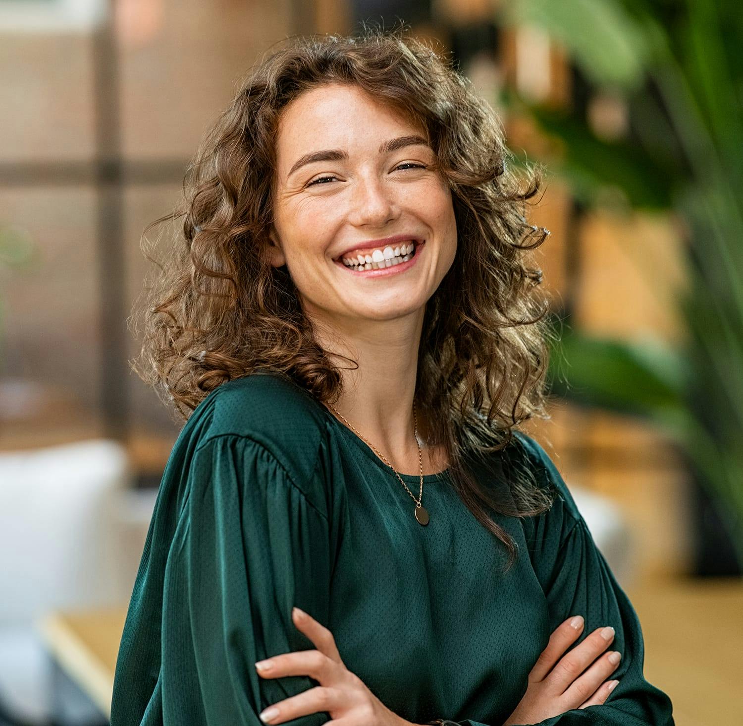 smiling woman with curly hair and green blouse