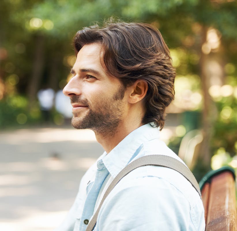 a man sitting on a bench in the park