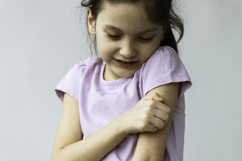Little girl scratching the eczema on her arm