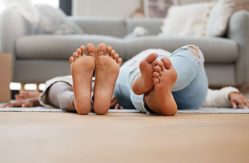 Two people laying on the floor with their feet facing the camera