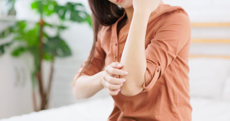 woman scratching arm