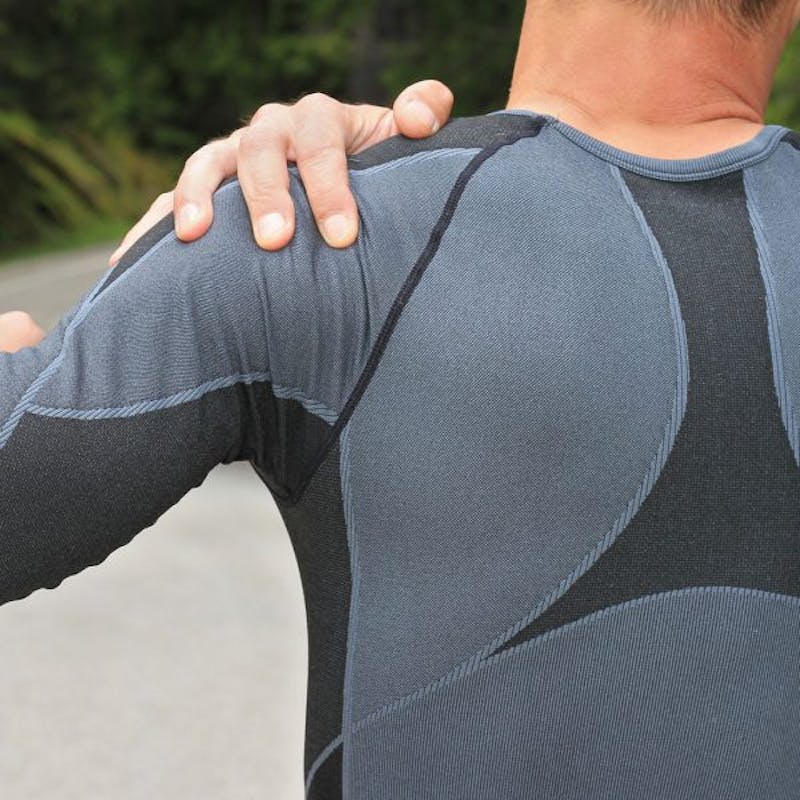 there is a man with a back pain holding his arm