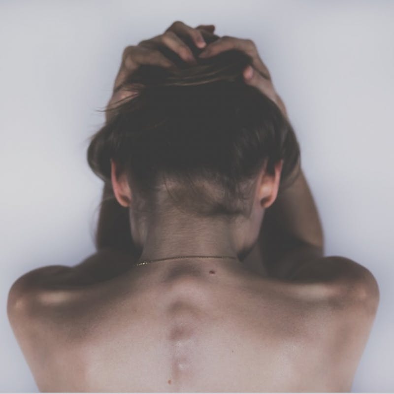 a close up of a woman bending to touch her face to her legs