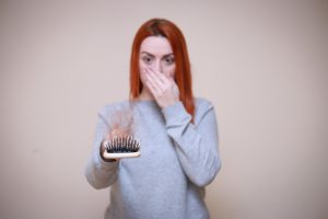 woman suprised at hair on hair brush